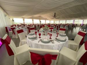 um quarto com mesas brancas e cadeiras com arcos vermelhos em Quinta Solar da Portela em Almodôvar