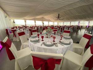 a room with white tables and chairs with red bows at Quinta Solar da Portela in Almodôvar