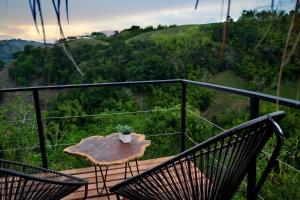 un balcón con 2 sillas y una mesa con una planta en Encanto Toscano, en Quimbaya