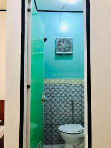 a small bathroom with a toilet and a shower at Wakim’s INN in Coron