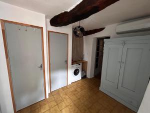 ヴィルクローズにあるLe petit Villecrozienのドアと洗濯機付きの部屋