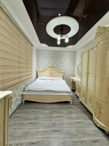 a bedroom with a king sized bed and a chandelier at Bonushka 5 in Uzbankinty