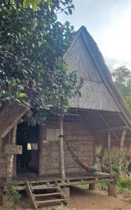 的住宿－OBT - The Papaya Bungalow，站在小屋外的妇女