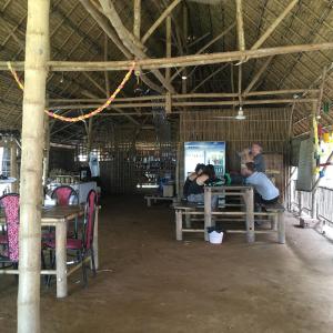 eine Gruppe von Personen, die an Tischen in einem Gebäude sitzen in der Unterkunft OBT - The Papaya Bungalow 