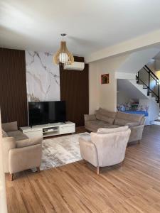 uma sala de estar com sofás e uma TV de tela plana em Villa with private pool em Durrës