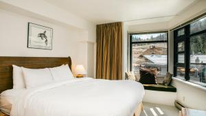 een slaapkamer met een groot bed en een raam bij Carleton Lodge in Whistler