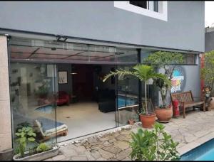 a glass extension of a house with a pool at Kaleidoscopio Hostel in Sao Paulo