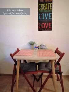drewniany stół z czterema krzesłami wokół niego w obiekcie Efi Studio 2 Lamia w mieście Lamia