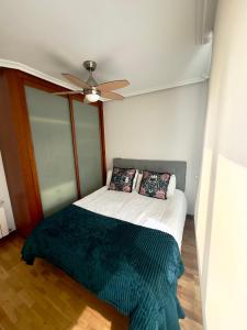um quarto com uma cama e uma ventoinha de tecto em Apartamento Costa del Sol Suances em Suances