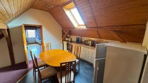 una cucina con tavolo in legno e soffitto in legno di Lausitzhof a Hoyerswerda