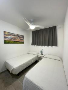 Pokój z 2 łóżkami i wentylatorem sufitowym w obiekcie Apartamento Playa vistas 2 w mieście Los Cristianos