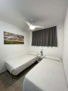 a room with two beds and a ceiling fan at Apartamento Playa vistas 2 in Los Cristianos