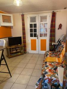 un soggiorno con un divano e una televisione di Kay Margo a Sainte-Luce