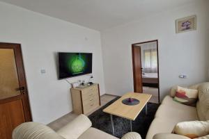 a living room with a couch and a tv on a wall at ViPo Vista Veliko Tarnovo in Veliko Tŭrnovo