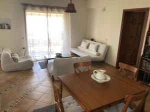 ein Wohnzimmer mit Tisch und Couch in der Unterkunft Olive Tree Bay in Lefokastro