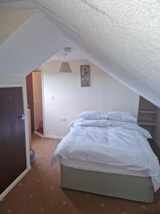 a bedroom with a white bed in a attic at Home from Home in Belfast