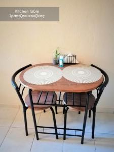 une table en bois entourée de deux chaises dans l'établissement Efi Studio 1 Lamia, à Lamía