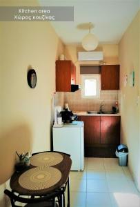 a small kitchen with a table and a white refrigerator at Efi Studio 1 Lamia in Lamía