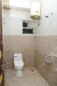 a bathroom with a toilet and a sink at HSR Parkside by Newstays in Bangalore