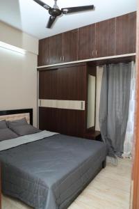 Schlafzimmer mit einem Bett mit einem Kopfteil aus Holz in der Unterkunft HSR Parkside by Newstays in Bangalore