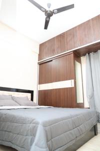 Schlafzimmer mit einem großen Bett mit einem Kopfteil aus Holz in der Unterkunft HSR Parkside by Newstays in Bangalore