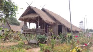 uma pequena cabana com telhado de palha em OBT -The Corn Bungalow 