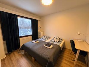 a bedroom with a bed and a desk and a window at Pine Sky Apartments in Ivalo