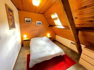 um quarto com uma cama branca num sótão em Maison 8-10 pers. à Loudenvielle em Loudenvielle