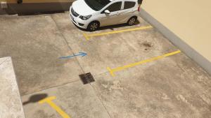 a small white car parked in a parking lot at Sweetness Wave Home in Quartu SantʼElena