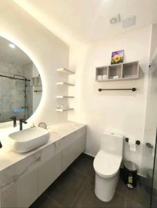 a white bathroom with a toilet and a sink at Luxury Building Studio - XOE in Quito