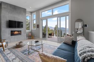 a living room with a blue couch and a fireplace at Luxury Home with Amazing Lake Okanagan Views in Kelowna