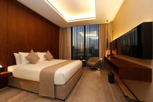 a hotel room with a bed and a desk at ALMA Hotel Riyadh in Riyadh
