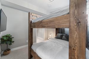 a bedroom with a wooden bunk bed with white sheets at Luxury Home with Amazing Lake Okanagan Views in Kelowna