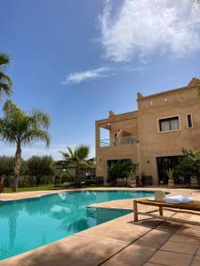 une maison avec une piscine en face d'une maison dans l'établissement Villa Dar Hadjar, à Marrakech