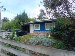 une maison bleue avec une clôture devant elle dans l'établissement Cabañas El Parque, à Las Flores
