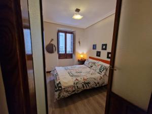 a small bedroom with a bed and a window at Airam Campanario in Almansa