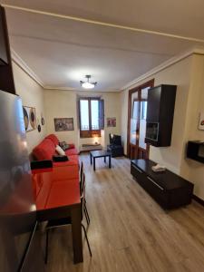 a living room with a red couch and a table at Airam Campanario in Almansa