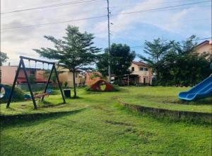 un patio con parque infantil con tobogán en tadzmahal home en Pagadían​