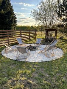 two chairs and a fire pit in a field at Leszczynowe Zacisze in Wiele