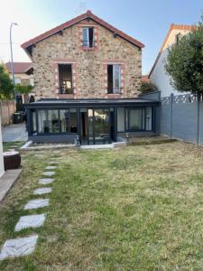 una casa con un patio de hierba delante de ella en Élégant Appartement Calme et Spacieux avec Jardin, en Choisy-le-Roi