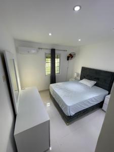 ein weißes Schlafzimmer mit einem Bett und einem Fenster in der Unterkunft Villa 1 in Santo Domingo