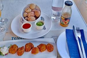 a table with two plates of food and a bowl of food at Wagner - Beach - Appartement in San Marcos +9 photos