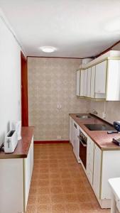 a kitchen with white cabinets and a sink at Wagner - Beach - Appartement in San Marcos