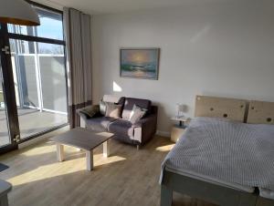 a living room with a couch and a bed at Ostseegolf - Ferienappartement in Hohen Wieschendorf
