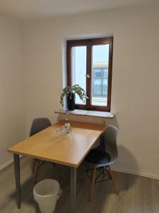 a wooden table with two chairs and a window at Luitpold14 Prichsenstadt in Prichsenstadt