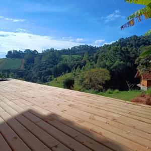 a wooden deck with a view of a mountain at Chalé Sonho Diniz 2 in Monte Verde