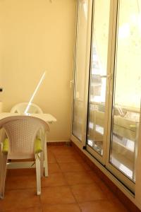 a table and chair in a room with a window at Ergi’s Host Apartment in Tirana
