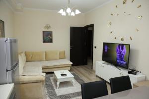 a living room with a couch and a tv at Ergi’s Host Apartment in Tirana