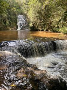 einem Wasserfall in der Mitte eines Flusses in der Unterkunft Chalé Sonho Diniz 2 in Monte Verde