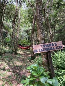un panneau au milieu d'une forêt dans l'établissement Chalé Sonho Diniz 2, à Monte Verde